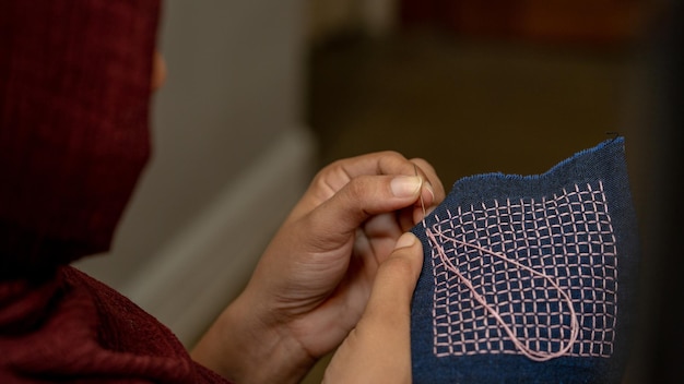 Mână care coase un model tradițional